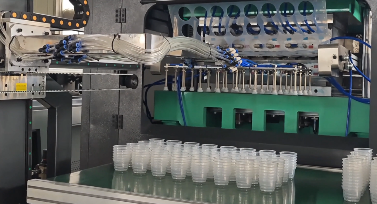 In‑mold robotic pick‑up system for cup thermoforming machine